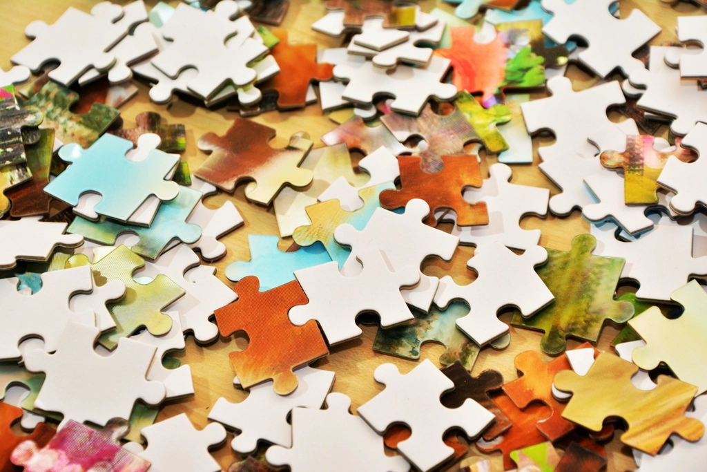 Colourful jigsaw puzzle pieces spread on a table